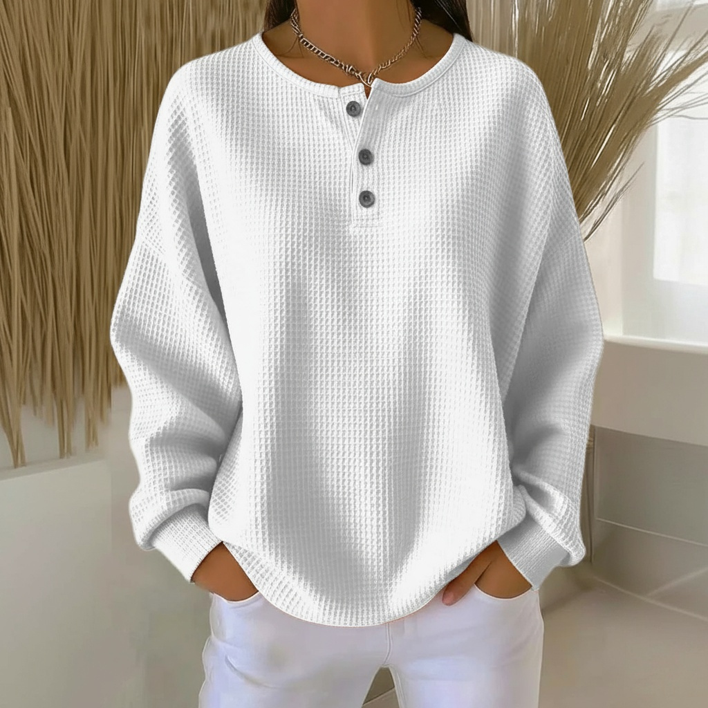 Close-up of a women's waffle knit sweater, highlighting the soft textured knit pattern and cozy fabric.