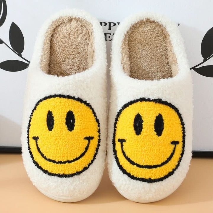 Warm women's house shoes with a cheerful smiley face and a cozy lining for winter comfort.