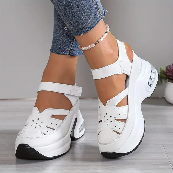 Closed toe women's wedge sandals. Breathable cutout upper, cushioned platform, and adjustable ankle strap.