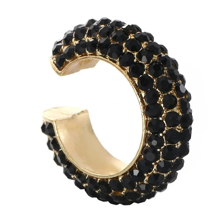 Hand holding a dazzling pavé crystal no-piercing ear cuff, showing intricate detail & sparkle.