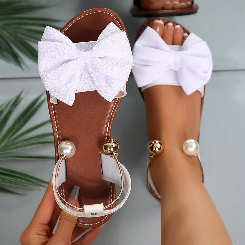 Stylish women's open-toe flat sandals for summer, featuring a lovely bow and intricate beadwork.
