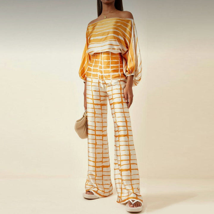 Vibrant women's one-shoulder abstract print two-piece pants set, perfect for a stand-out vacation or evening look.