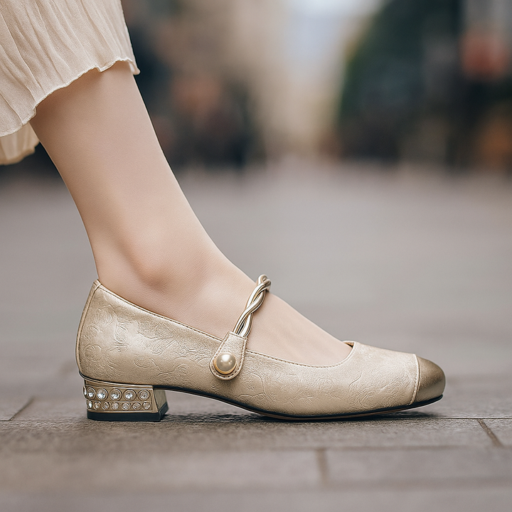 Close-up of elegant women's pearl flats featuring a metallic toe and cushioned interior.