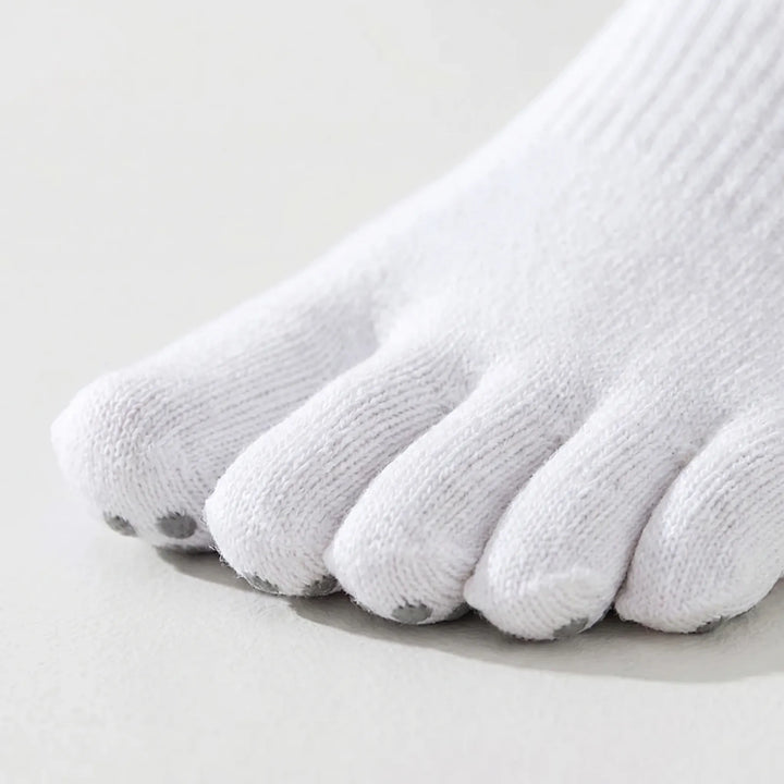Woman's feet in five-toe activewear grip socks, showcasing comfort & improved balance for yoga, pilates & exercise.