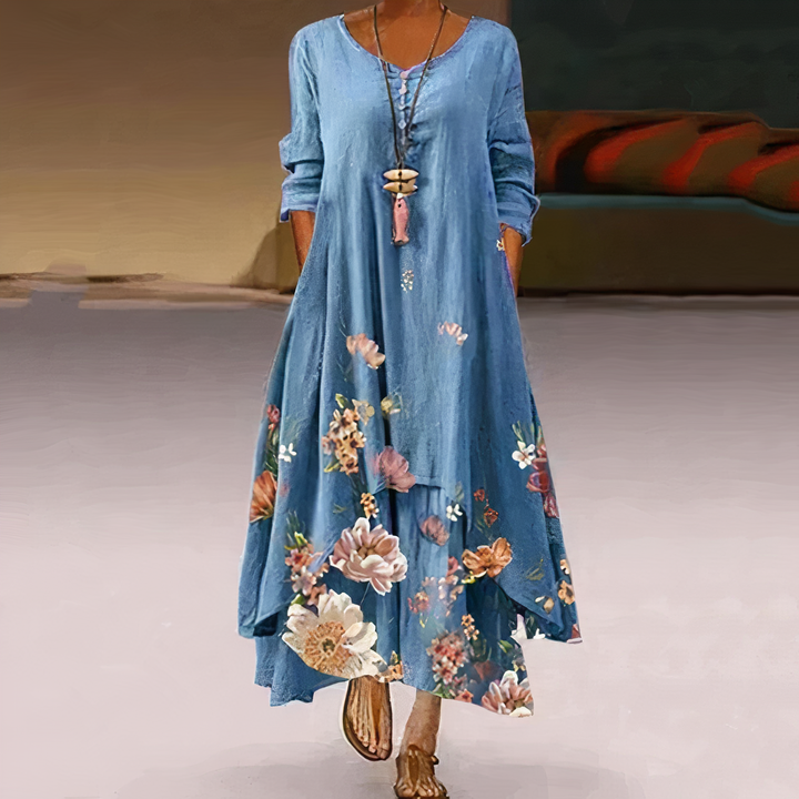 Woman models flowy long sleeve floral maxi dress. V-neck, A-line cut, bohemian style for spring/summer fashion.