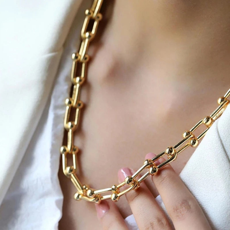 Close-up of sparkling gold link chain, gold-plated stainless steel. Part of women's elegant jewelry set.