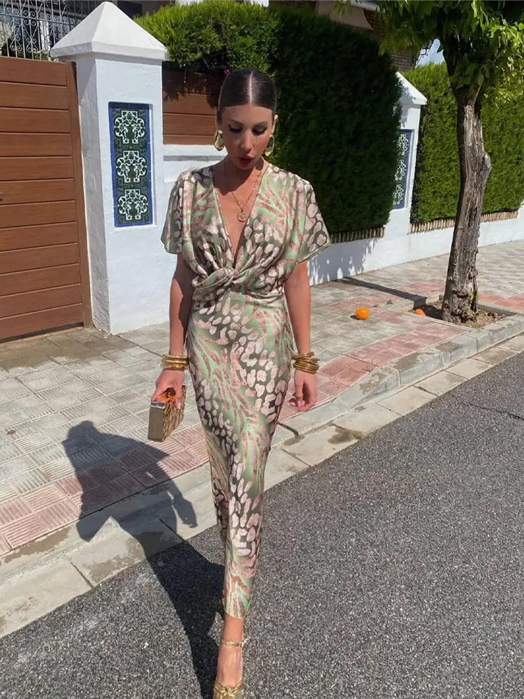 Elegant women's printed wrap midi dress, relaxed fit. Ideal party, vacation, or occasion wear. Green abstract design.