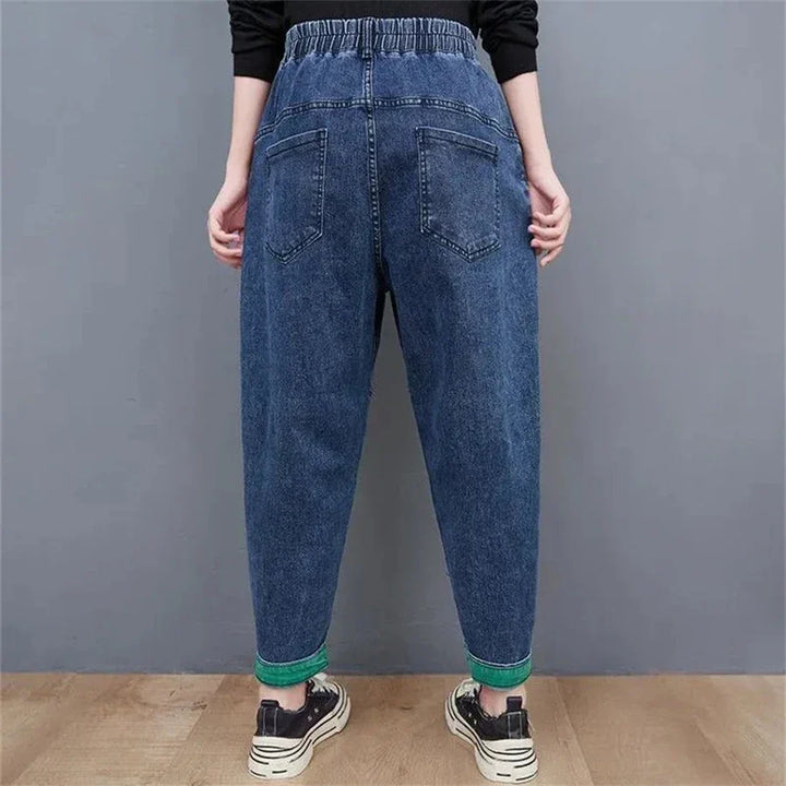 Back view of women's comfortable loose-fit denim jeans: high-waisted, baggy, & ankle-length for style.