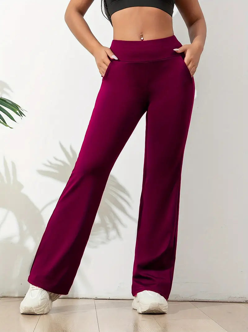 Full-length women's high-waisted flared active pants in black, offering flattering fit & flexibility for workouts.