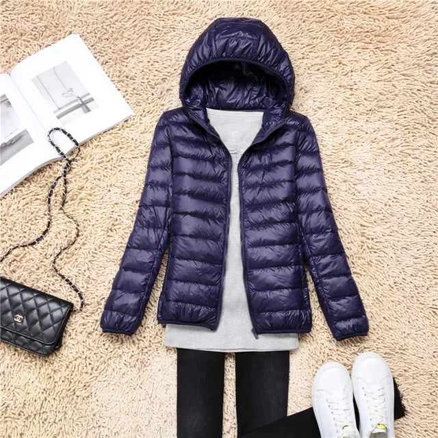 Insulated women's hooded jacket. Lightweight, packable, perfect for cold weather & travel.