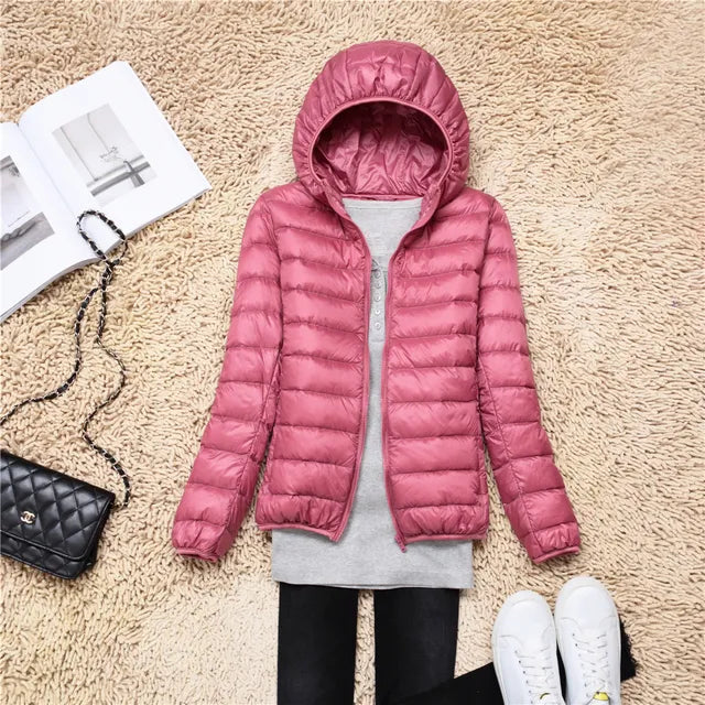 Lightweight women's packable hooded jacket, insulated for warmth & travel comfort.