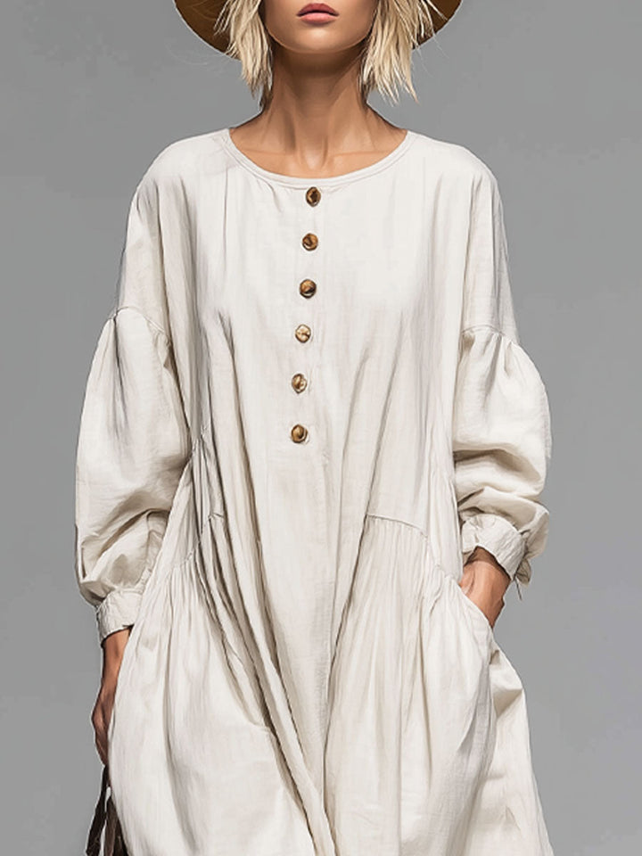 Casual women's long-sleeved midi dress featuring a button front, loose fit, and practical pockets. Versatile day dress.