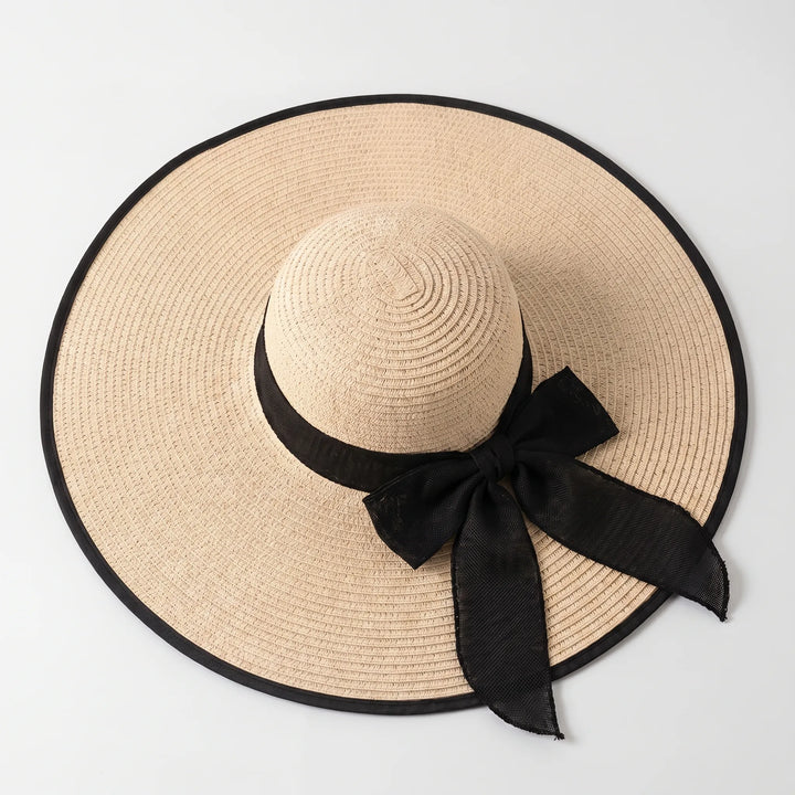 Stylish women's wide brim floppy sun hat in neutral, ideal for summer beachwear & vacation travel accessory.