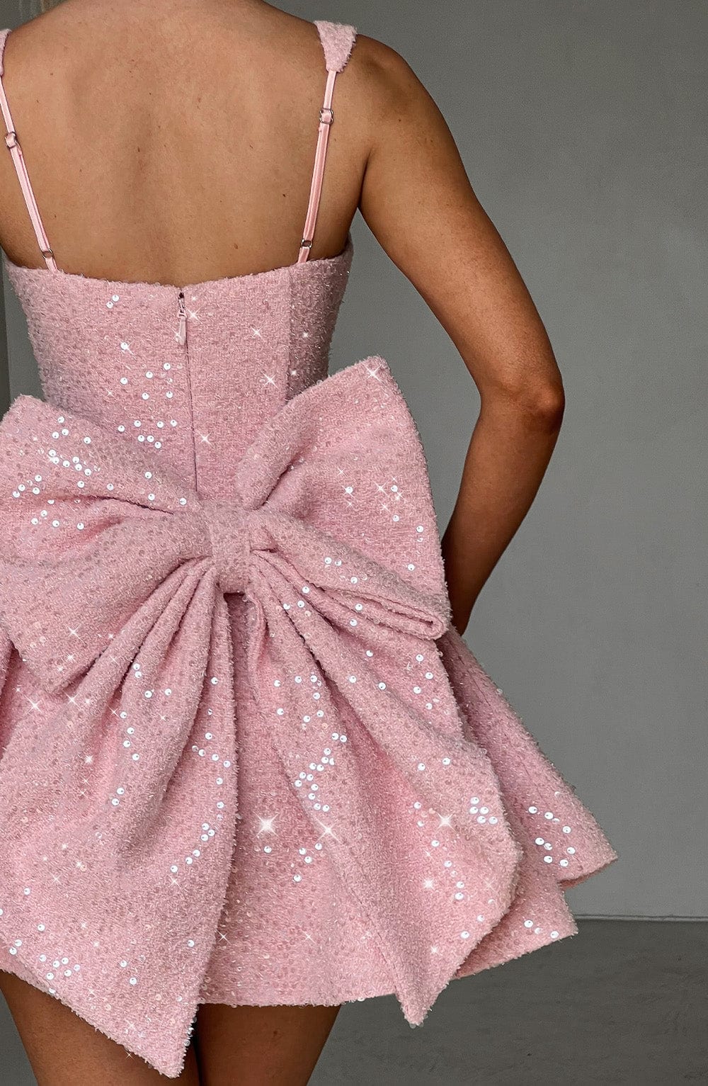 Dazzling short pink sequin skater homecoming dress for women, featuring a stylish bow and flared skirt.