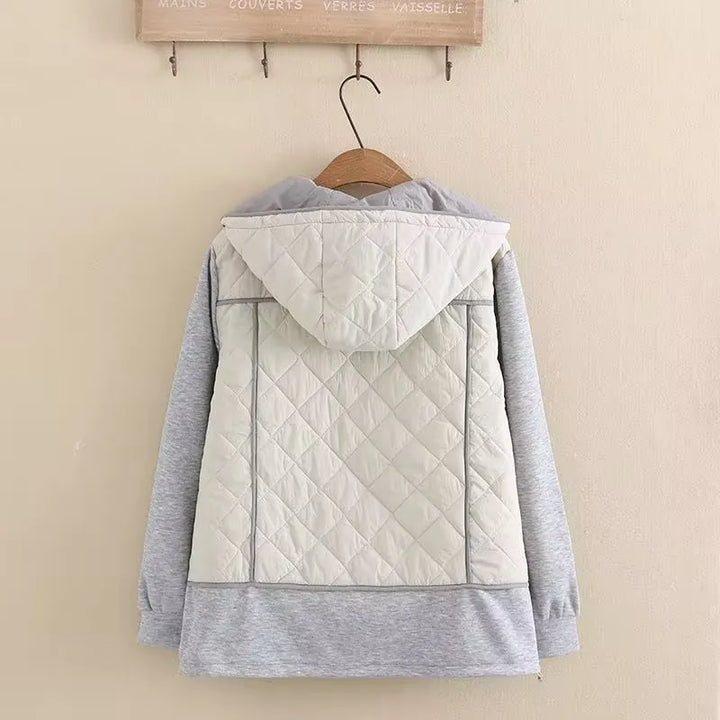 Woman wearing a plus size diamond quilted hooded jacket, showcasing its comfortable fit.