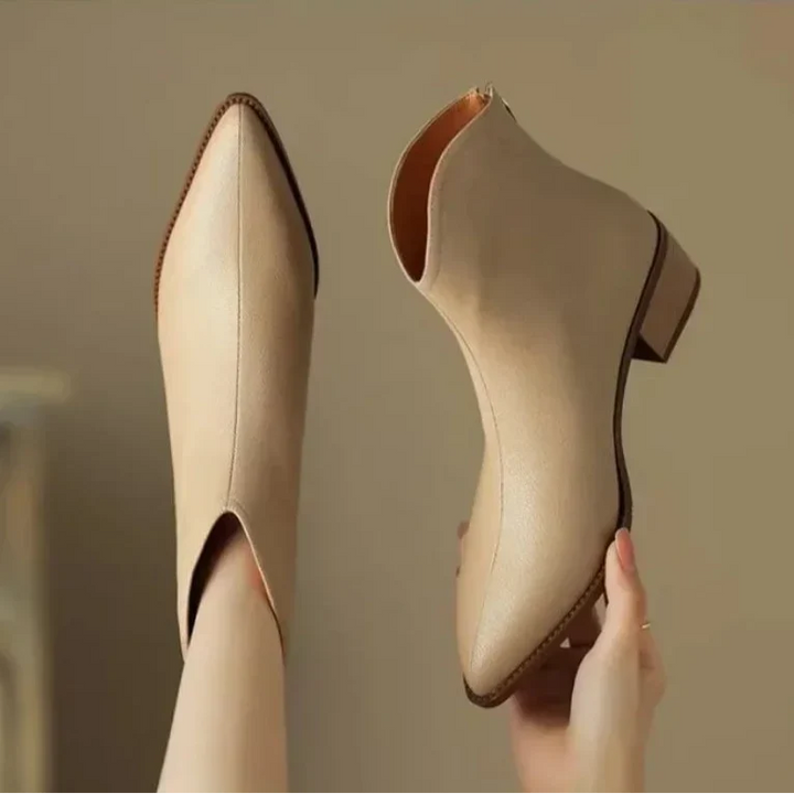View of sleek pointed toe women's ankle boots, low heel, and convenient slip-on style.