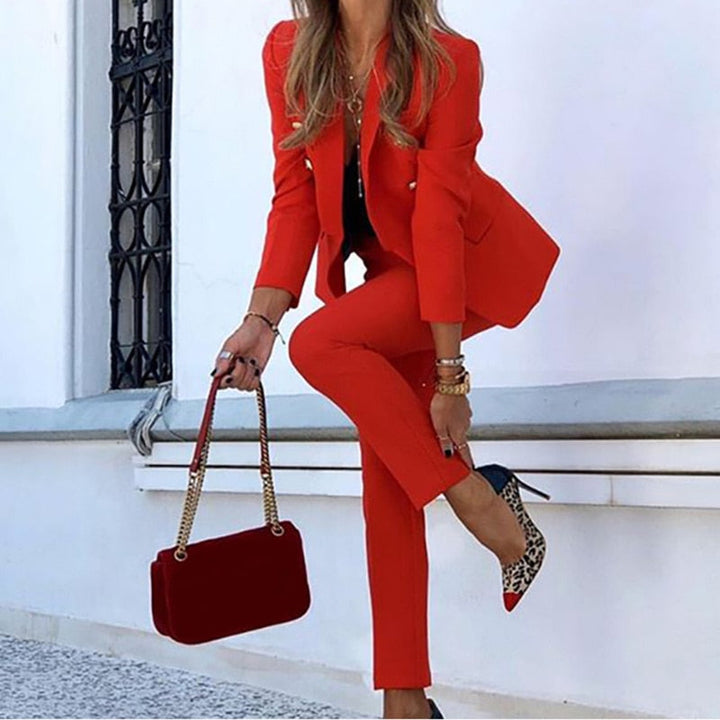 Chic women's double-breasted blazer and matching tailored pants. A stylish two-piece formal office suit.