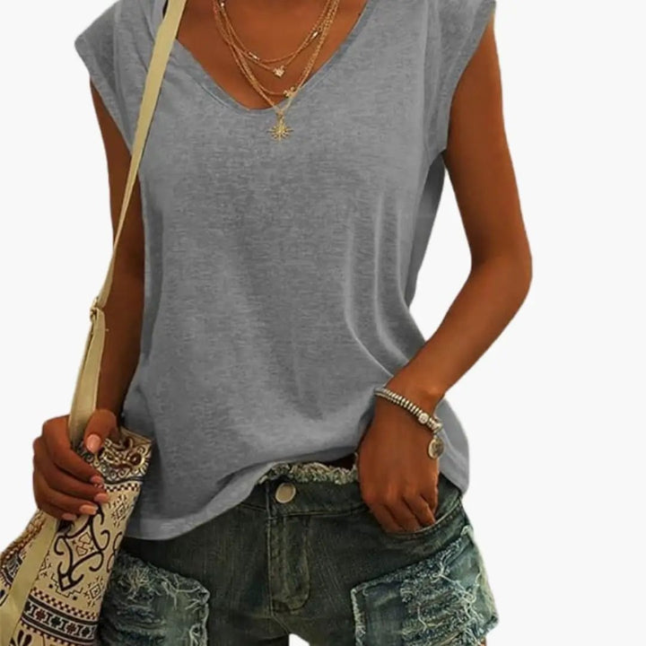 Versatile women's relaxed sleeveless V-neck top, shown layered under a cardigan for a chic look.