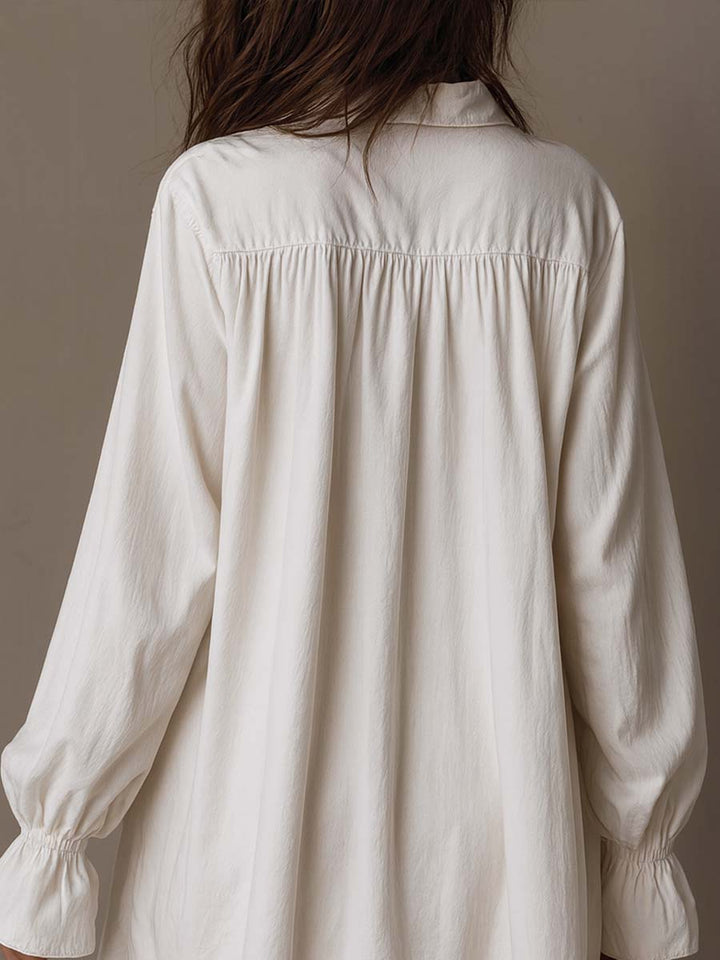White women's retro mini dress, long sleeves & elegant irregular hem. Vintage-inspired for parties or stylish casual looks.