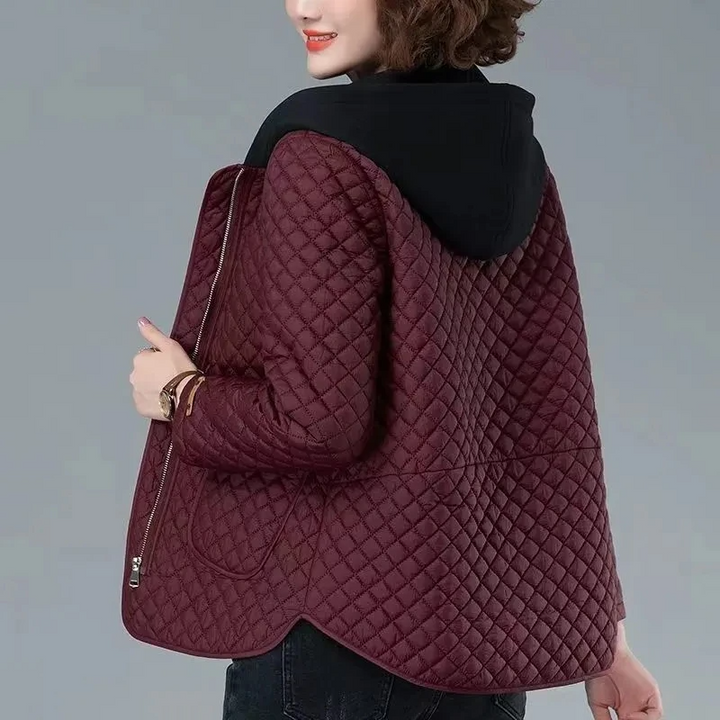 Modern women's diamond-quilted coat featuring an asymmetrical hem, side zip, and hood for stylish comfort.
