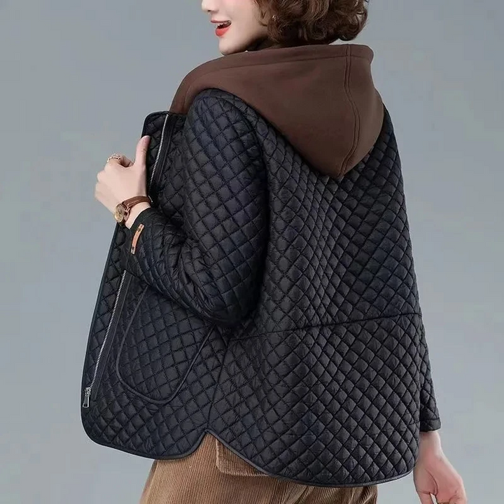 Stylish women's transitional quilted jacket with unique asymmetrical hem, side zip, and hood. Ideal for spring/fall.