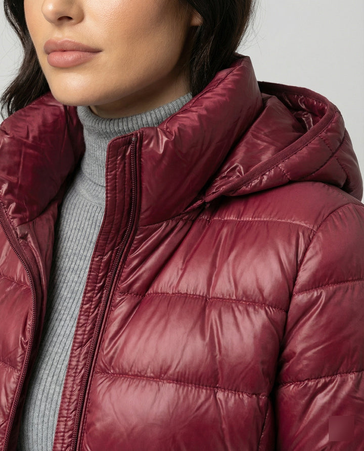 Packable women's insulated jacket with hood, lightweight & wind resistant for transitional weather.