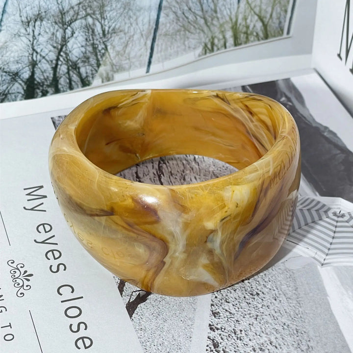 Trendy women's irregular marble acrylic bangle bracelet. Eye-catching unique pattern fashion accessory.
