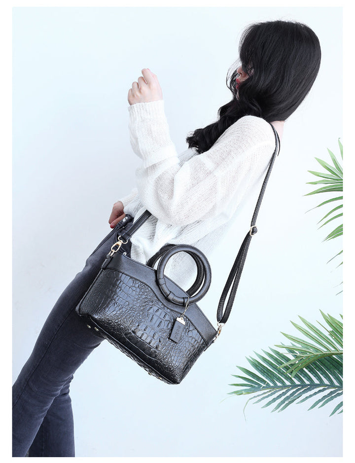 Vintage-inspired women's handbag, round handle, with sophisticated alligator embossing.